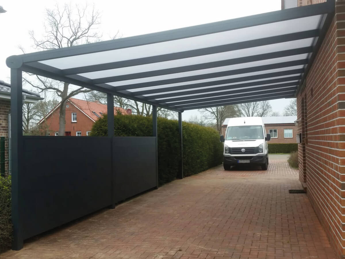 Überdachtes Carport eines Einfamilienhauses mit Zaunelementen als Wetter- und Sichtschutz