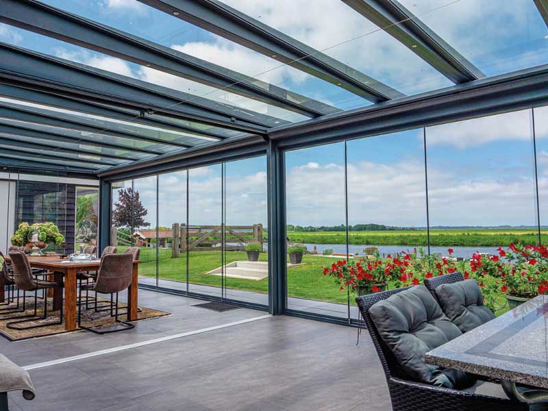 Exklusive Aluminium-Terrassenüberdachung mit Glasdach und raumhohen Glasschiebewänden
