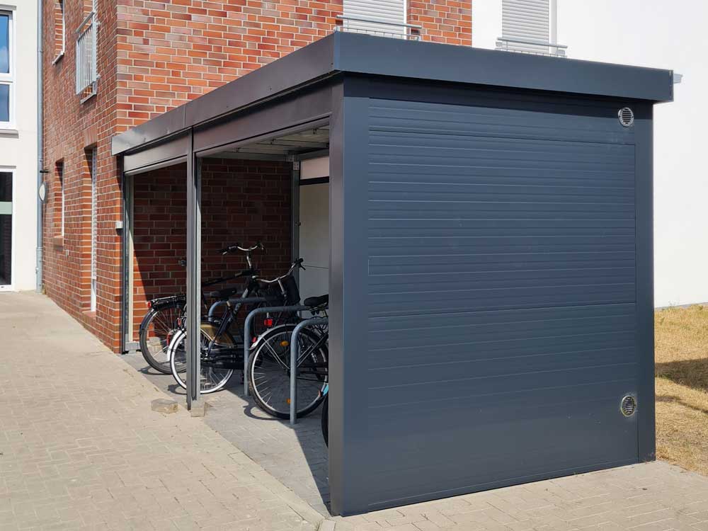 Moderner Aluminium-Fahrradunterstand in Anthrazit mit Rollladen und Überdachung, wetterfeste Abstelllösung für Mehrfamilienhäuser