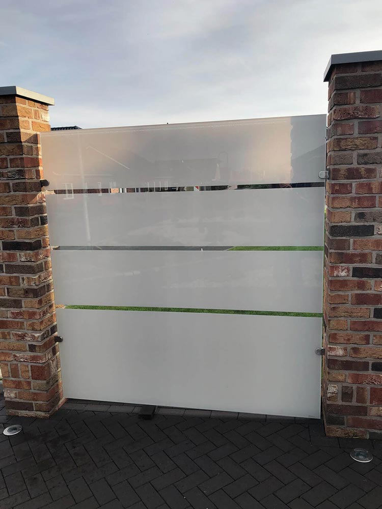 Modernes Glas-Sichtschutzelement mit horizontalen Streifen zwischen Klinkerpfeilern